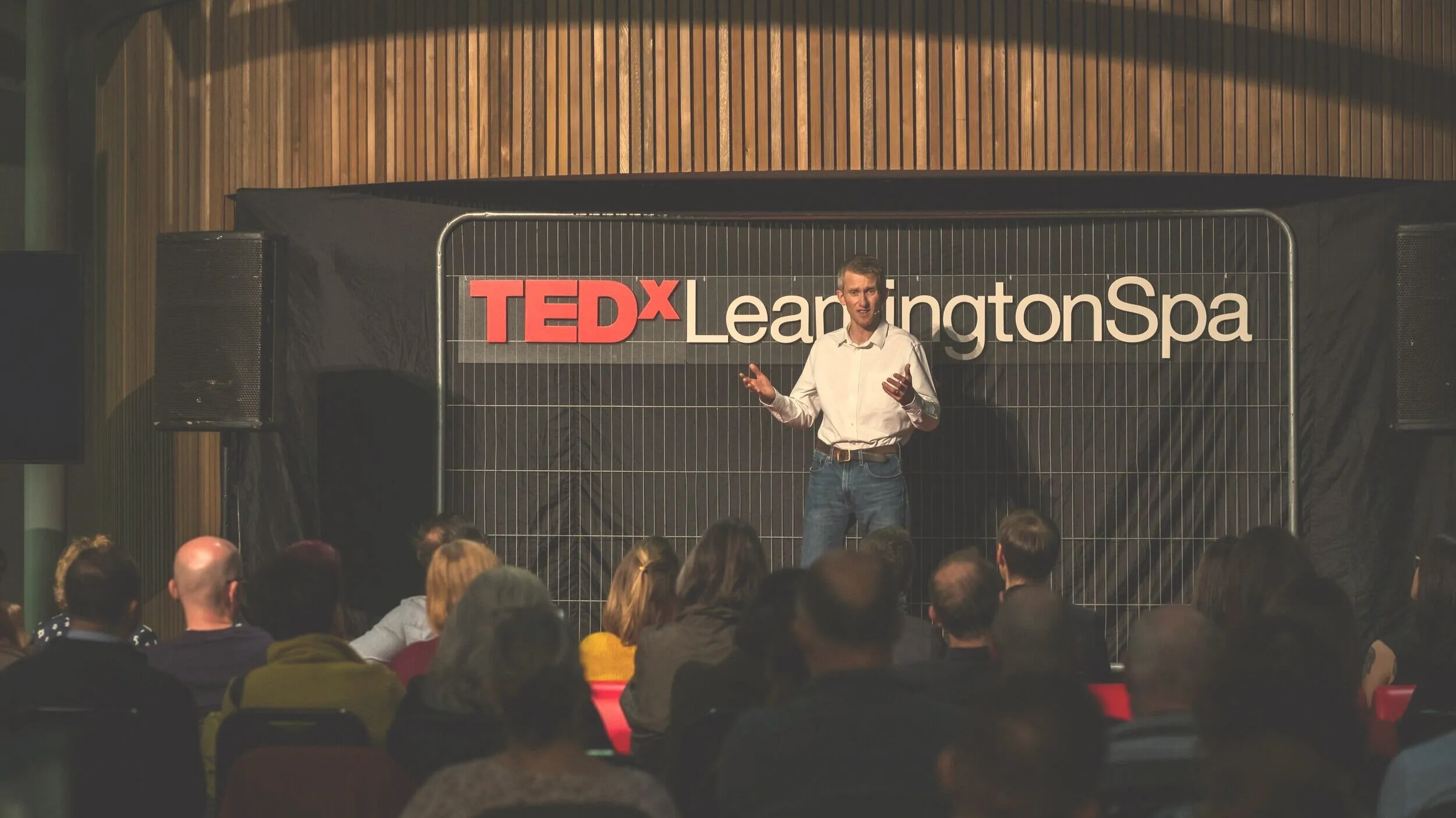 Andrew Pain delivering his TEDx talk to a seated audience