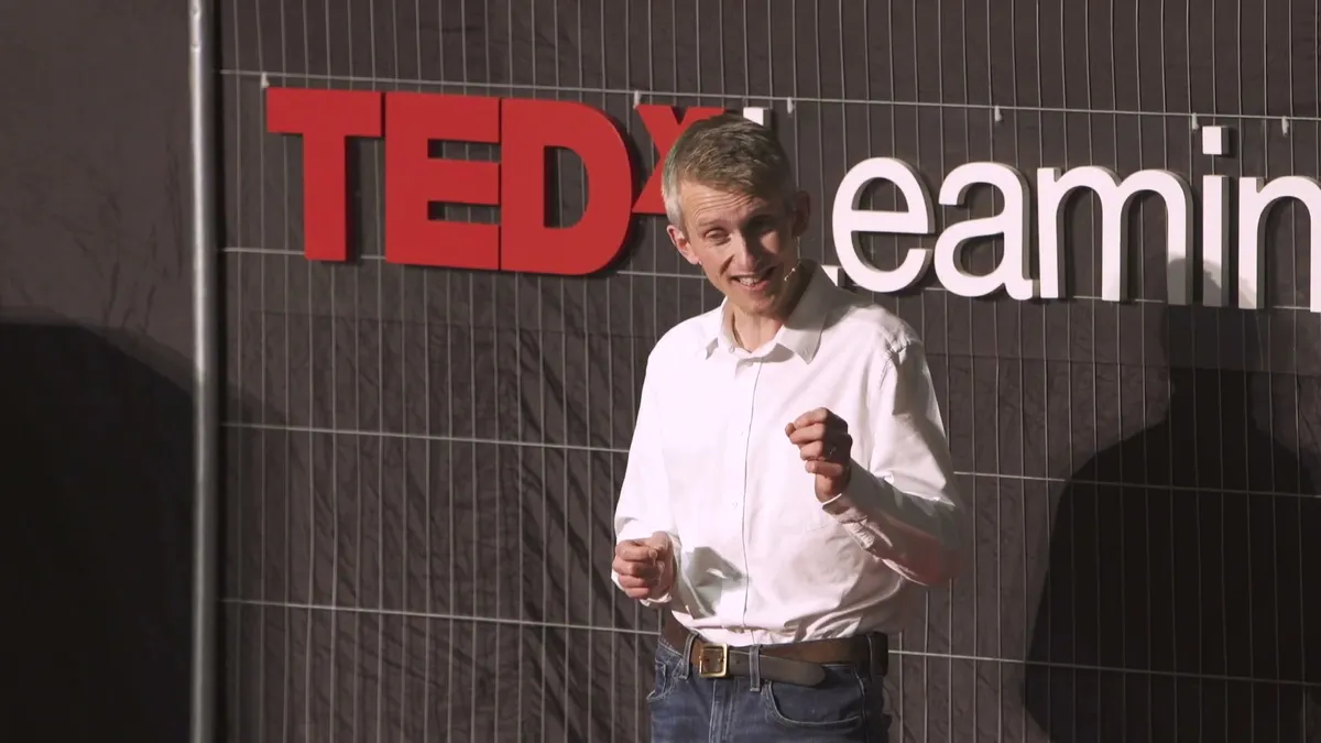 Andrew Pain delivering his TEDx talk on stage